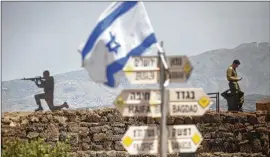  ?? LIOR MIZRAHI / GETTY IMAGES ?? An Israeli soldier is seen on Mount Bental next to the Syrian border on Thursday in the Israeli-annexed Golan Heights. Some 20 rockets were fired at Israeli military bases by Iranian forces from southern Syria just after midnight on Thursday, sparking...