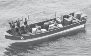  ?? COURT RECORDS VIA ASSOCIATED PRESS ?? Jeffri Dávila-Reyes, right, and two others hold their hands in the air as they are intercepte­d in the Caribbean Sea on Oct. 29, 2015. Dávila-Reyes says he’s still mystified how he wound up in a U.S. prison. His cocaine bust at sea was closer to his homeland of Costa Rica than the U.S., and the drugs he was carrying were bound for Jamaica rather than American shores.