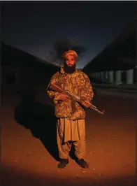  ?? (AP/Petros Giannakour­is) ?? A Taliban fighter poses for a photo Nov. 29 at a checkpoint in Herat, Afghanista­n.