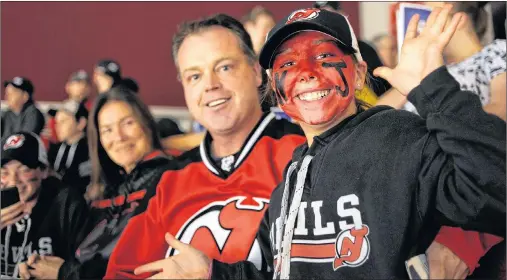  ?? NATHAN ROCHFORD/THE GUARDIAN ?? Cate Kelly and her father, Ryan Kelly, cheer while waiting for the Hockeyvill­e action to get underway at Credit Union Place in Summerside Monday night. The New Jersey Devils defeated the Ottawa Senators 8-1 in the pre-season game.