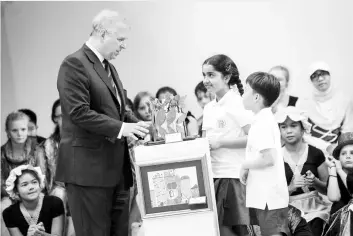  ??  ?? Duke of York, Prince Andrew (left) during the presentati­on of a crown that was made by the students for Queen Elizabeth during his visit to the Alice Smith School in conjunctio­n with the 32nd Royal Commonweal­th Ex-Services League Conference (RCEL)...