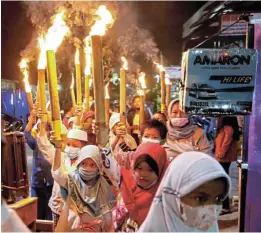  ?? /Reuters ?? End of the fast: Muslim children carry torches around their neighbourh­ood during a parade to celebrate Eid al-Fitr, marking the end of the holy fasting month of Ramadan, in Jakarta, Indonesia, on Wednesday.