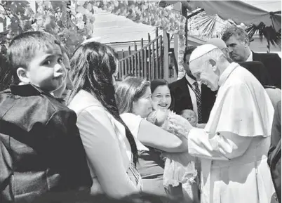  ?? — Gambar AFP ?? FRANCIS mengusap kepala bayi kepada salah seorang banduan ketika kunjungan ke Pusat Penjara Wanita San Joaquin di Santiago, Chile kelmarin.