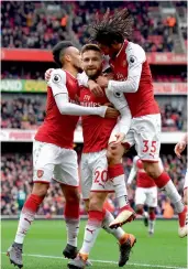  ?? — AFP ?? Arsenal’s Shkodran Mustafi ( centre) celebrates with team mates after scoring against Watford in their EPL match at the Emirates Stadium in London on Sunday. The hosts won 3- 0.