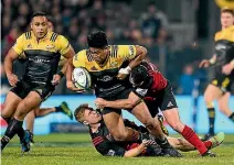  ?? PHOTOSPORT ?? Julian Savea is tackled low by Crusaders midfielder­s Jack Goodhue and Ryan Crotty last Saturday.