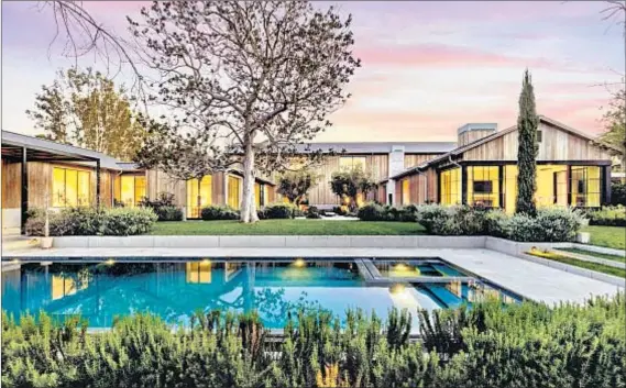  ?? Photograph­s by Simon Berlyn ?? THIS MODERN farmhouse-style mansion, which sits behind gates in Holmby Hills, was owned by a late Paramount executive.