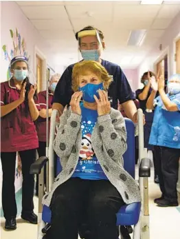 ?? JACOB KING AP ?? Margaret Keenan, 90, is applauded by staff after becoming the first patient in the United Kingdom to receive the Pfizer-BioNTech COVID-19 vaccine on Dec. 8.