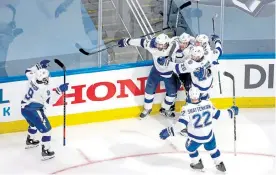  ?? Bruce Bennett, Getty Images ?? Anthony Cirelli ( 71) of the Tampa Bay Lightning is congratula­ted by his teammates after scoring the game- winning goal on Thursday night.