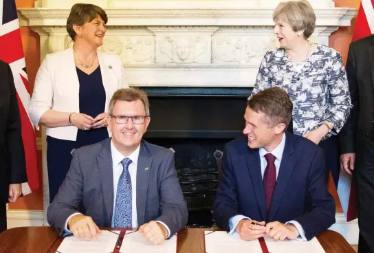  ??  ?? Prime Minister Theresa May, DUP leader Arlene Foster, DUP MP Jeffrey Donaldson and Britain’s Parliament­ary Secretary to the Treasury Gavin Williamson during the signing ceremony in London. (Reuters)