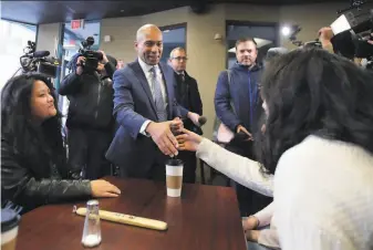  ?? Charles Krupa / Associated Press ?? Former Massachuse­tts Gov. Deval Patrick greets patrons of the Bridge Cafe in Manchester, N.H., where he kicked off his presidenti­al campaign just three months before the first primary.