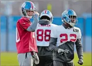  ?? SETH WENIG/AP PHOTO ?? Eli Manning, left, participat­es in practice Wednesday after being named the Giants’ starting quarterbac­k again.