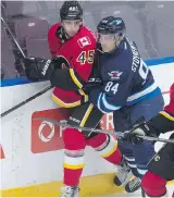  ?? SHAUGHN BUTTS ?? Morgan Klimchuk of the Flames Prospects is checked by Peter Stoykewych of Winnipeg at last season’s Young Stars tournament in Penticton.