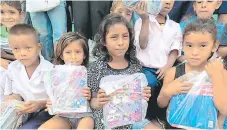  ??  ?? Estos pequeños mostraron sus paquetes educativos luego de escudriñar lo que les habían donado.