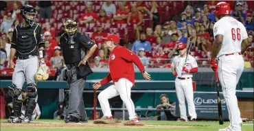  ?? JOHN MINCHILLO / AP ?? Cincinnati Reds manager David Bell runs to argue with umpire Larry Vanover over a called strike to Yasiel Puig during the ninth inning Tuesday against the Pittsburgh Pirates at Great American Ball Park.