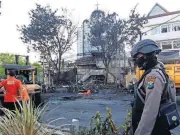  ?? [AP PHOTO] ?? A police officer stands guard at one of the sites of church attacks Sunday in Surabaya, East Java, Indonesia.