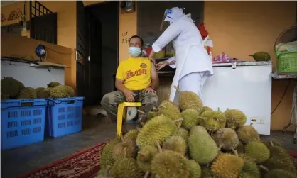  ?? Photograph: Vincent Thian/AP ?? A nurse administer­s a Pfizer vaccine to a durian fruit vendor at his house in rural Malaysia