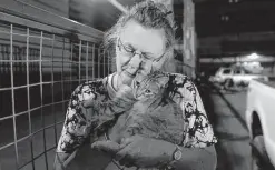  ?? Nathan Howard / Associated Press ?? Dee McCarley hugs her cat Bunny at a Red Cross center on Wednesday in Klamath Falls, Ore., after evacuating from the massive lightning-caused Bootleg Fire, the largest in the U.S. It is burning in Klamath tribal territory in southern Oregon.