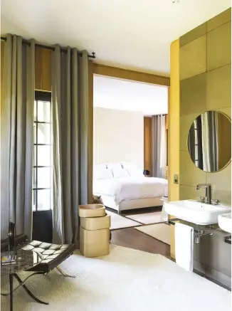  ??  ?? ABOVE The master bedroom’s en suite bathroom is decorated like a living room with its soft carpet, curtains and vintage Mies van der Rohe ‘Barcelona’ chair for Knoll. The sink is from Laufen and the tap is by Axor BELOW Located above the villa, the...