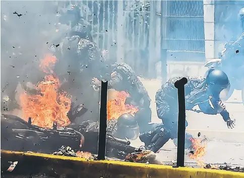  ??  ?? Police officers react after an explosive device exploded as they rode past during a protest against the elections for a Constituen­t Assembly in Caracas . — AFP photo