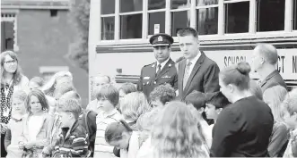  ??  ?? Transporta­tion Minister Todd Stone, with Victoria acting police chief Del Manak and students outside the legislatur­e on Monday, announced tougher penalties for drivers passing on-duty school buses.