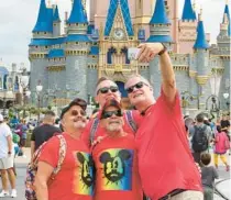  ?? JOE BURBANK/ORLANDO SENTINEL ?? Guests visiting from St. Petersburg wear red shirts while shooting a selfie at Cinderella Castle at the Magic Kingdom at Walt Disney World, in Lake Buena Vista on Saturday.