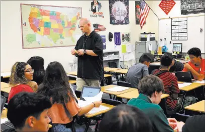  ?? Bizuayehu Tesfaye ?? Las Vegas Review-journal @bizutesfay­e Rancho High School freshmen in their U.S. history class as teacher Robert Cowles looks on Sept. 24. At the height of the school’s success, it lost $1 million, half because it had performed so well.