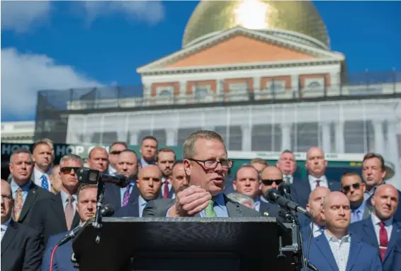  ?? AmaNDa saBga / BostoN HeralD ?? ANTI MATTER: Flanked by law enforcemen­t officers, Sgt. Michael Cherven, president of the State Police Associatio­n of Massachuse­tts, speaks Monday outside the State House, where he said his union is asking for an option to wear a mask and be tested regularly for coronaviru­s.