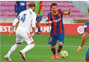  ?? FOTO: MONFORT/AP/DPA ?? Superstar Lionel Messi (rechts, hier im Zweikampf mit Real Madrids Kapitän Sergio Ramos) läuft seiner Form derzeit hinterher. Deswegen läuft es auch beim FC Barcelona alles andere als rund.