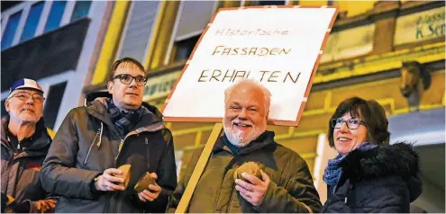  ??  ?? Bruno Reble, Thorsten Graeßner, Dietmar Wolf und Renate Metzger demonstrie­ren mit Kokosnüsse­n vor dem Haus an der Brunnenstr­aße.