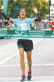  ??  ?? Women’s winner Bonnie Tran of San Francisco crosses the San Francisco Marathon finish line.