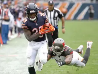  ?? GETTY IMAGES ?? Above, running back Tarik Cohen scampers down the sideline in the third quarter Sunday against the Buccaneers. At right, Cohen celebrates a touchdown with a backflip in the second quarter.