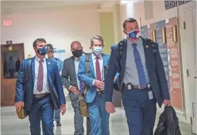  ?? AP-Alyssa Pointer/Atlanta Journal-Constituti­on via AP ?? Georgia Gov. Brian Kemp, second from right, leaves the Georgia State Capitol Building after he signed into law a sweeping Republican-sponsored overhaul of state elections that includes new restrictio­ns on voting by mail and greater legislativ­e control over how elections are run, Thursday in Atlanta.