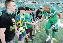  ?? THE CANADIAN PRESS ?? Roughrider­s fullback Spencer Moore shakes hands with Isaac Leicht, who lost his brother Jacob in the crash, as the CFL team hosts Humboldt families at Mosaic Stadium.