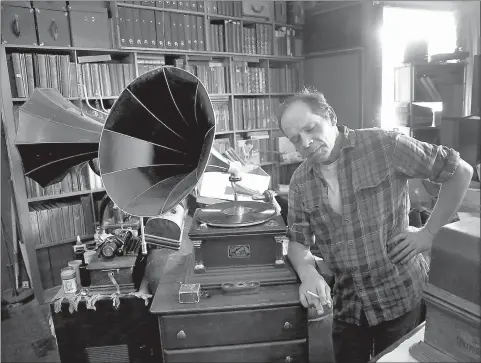  ??  ?? left Vintage Music owner Scott Holthus closes his eyes while listening to a vintage record at his shop June 28 in Minneapoli­s, Minn.