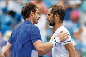  ?? ROB CARR / GETTY IMAGES ?? Andy Murray (left) shakes hands with Richard Gasquet after losing in straight sets at the Western and Southern Open on Monday in Mason. Gasquet will play fourth-seeded Dominic Thiem in the second round.