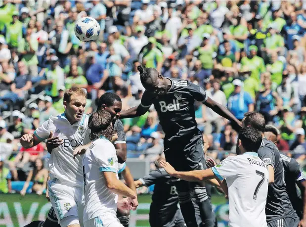  ?? — THE ASSOCIATED PRESS FILES ?? Whitecaps forward Kei Kamara, centre, heads the ball out of harm’s way after a corner kick by the Sounders during a game on July 21 in Seattle. The Sounders won the game 2-0, kicking off an MLS record eight straight wins. They’re unbeaten in 11 starts.