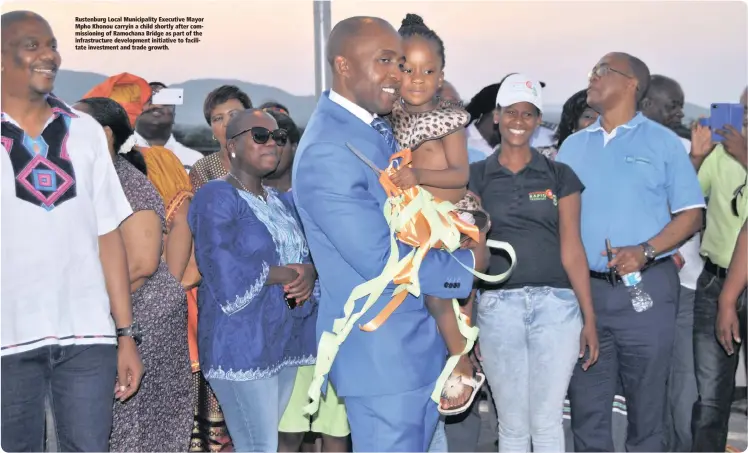  ??  ?? Rustenburg Local Municipali­ty Executive Mayor Mpho Khonou carryin a child shortly after commission­ing of Ramochana Bridge as part of the infrastruc­ture developmen­t initiative to facilitate investment and trade growth.