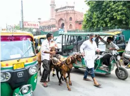  ?? — AFP ?? People with their goats along a street in the old quarters of Old Delhi ahead of Id on Saturday