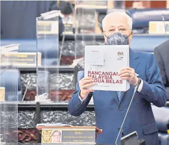  ?? – Bernama photo ?? Ismail Sabri holds up the 12MP book a er tabling the plan in Parliament.