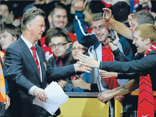  ?? Photo: GETTY IMAGES ?? Man, united: Manager Louis Van Gaal is congratula­ted by Manchester United fans after United won his first home match in charge, against Valencia.