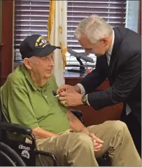  ??  ?? Top photo, Cumberland native, Sergeant First Class (SFC) Ernest “Ernie” Mallory, 94, receives a service medal from U.S. Senator Jack Reed during a medal ceremony honoring the Army veteran. Right, Mallory is surrounded by family at the ceremony for a photo.