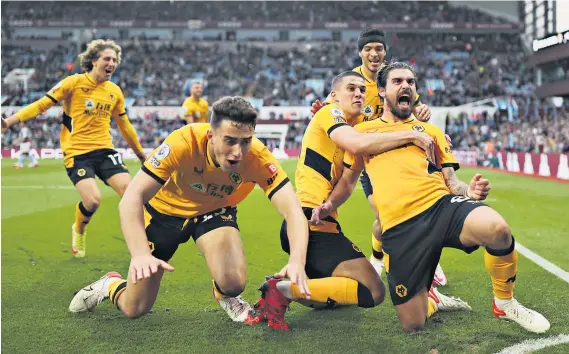  ?? ?? Old gold and bold: Ruben Neves (right) is mobbed after scoring the winning goal from a free-kick deep into stoppage time to complete an impressive fightback at Villa Park