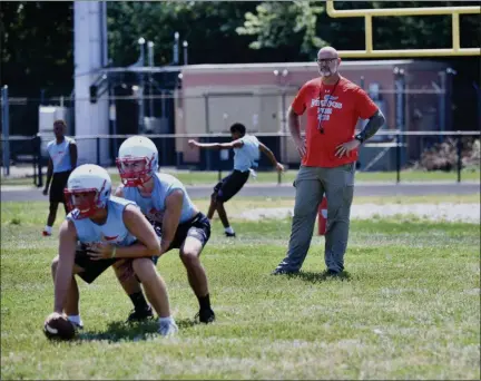  ?? PAUL DICICCO — FOR THE NEWS-HERALD ?? Kevin Eiseman takes a snap as Coach Elvis Grbac looks on during VASJ practice Aug. 1