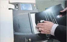  ?? CHRIS YOUNG THE CANADIAN PRESS ?? Chief Electoral Officer Greg Essensa slides a ballot into a vote tabulator as he demonstrat­es an electronic voting machine this week in Toronto.