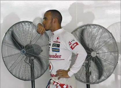  ?? REUTERS / EDGAR SU ?? Lewis Hamilton es recolza en uns ventilador­s després de fer el millor temps en la qualificac­ió de Malàisia.