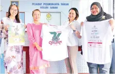  ??  ?? Sempini (second left) with the 18th Sutera Harbour 7k Sunset Charity Run T-shirt after the briefing.