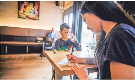  ?? FOTO: ANNE ORTHEN ?? Eine Frau füllt den Erfassungs­bogen in einem Restaurant aus. Gastwirte vertrauen auf korrekte Angaben ihrer Kunden.