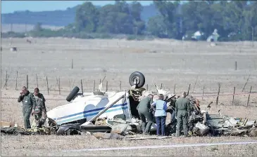  ?? Picture: HENK KRUGER ?? SEARCHING FOR CLUES: SA Air Force members inspect the scene where an aircraft crashed on a farm near the SA Air Force base in Langebaanw­eg. Two pilots are in a critical condition at Life West Coast Private Hospital.