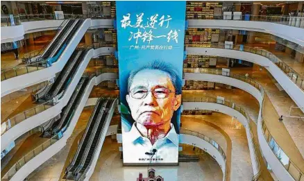  ?? Reuters ?? Banner com autoridade chinesa que investiga o coronavíru­s estendido em shopping vazio em Guangzhou, na China