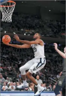  ?? KATHY WILLENS — THE ASSOCIATED PRESS ?? Villanova’s Mikal Bridges swoops in and shoots in front of Marquette center Matt Heldt early on Thursday night in the Wildcats’ victory in the Big East Tournament at Madison Square Garden.